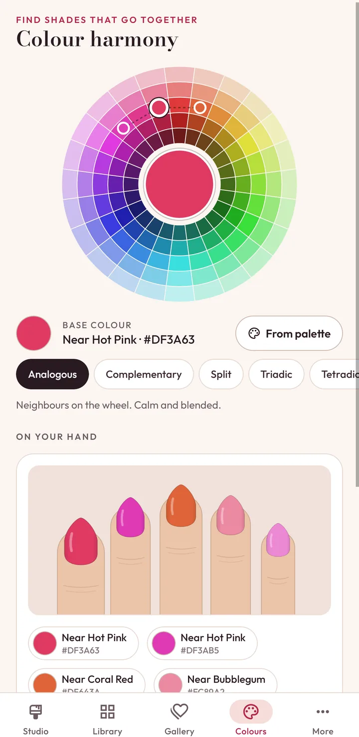 The colour wheel with an analogous harmony selected and the matching colours painted on a hand.